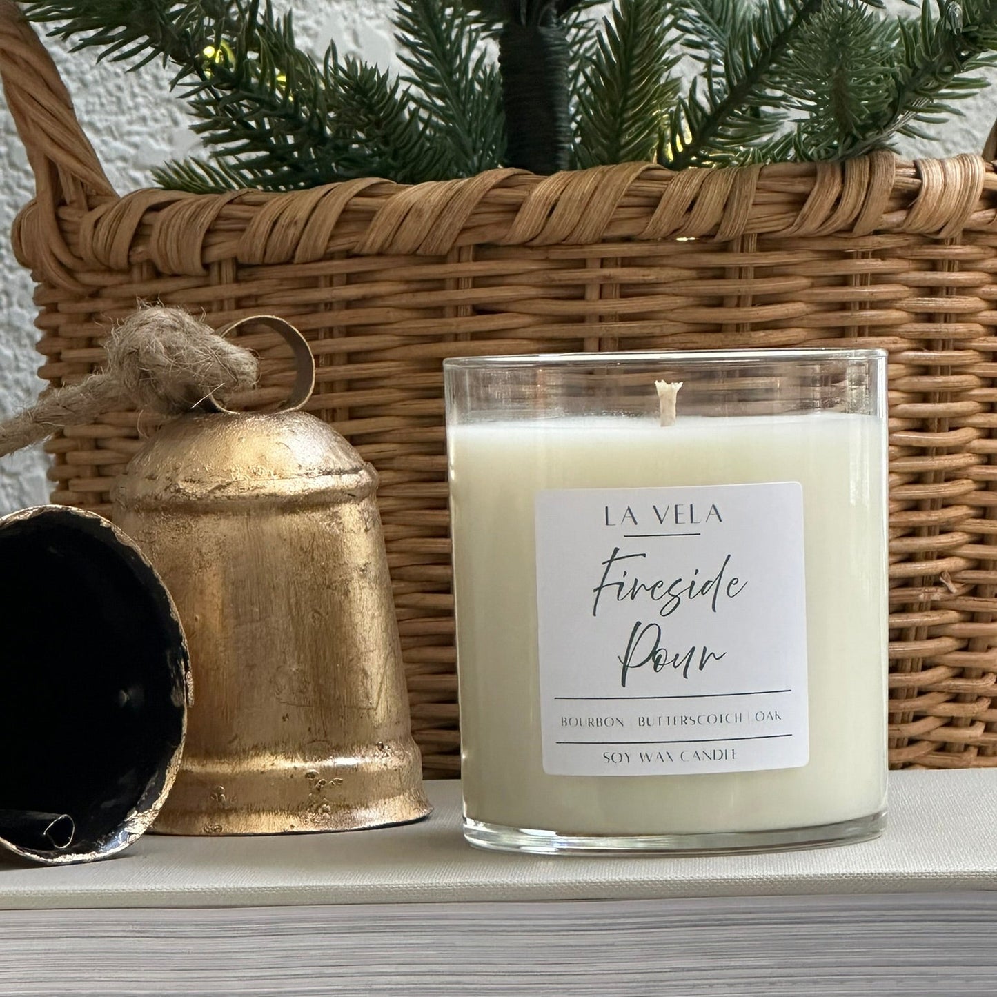 Candle labeled 'Fireside Pour' by 'La Villa' on a surface with decorative items.